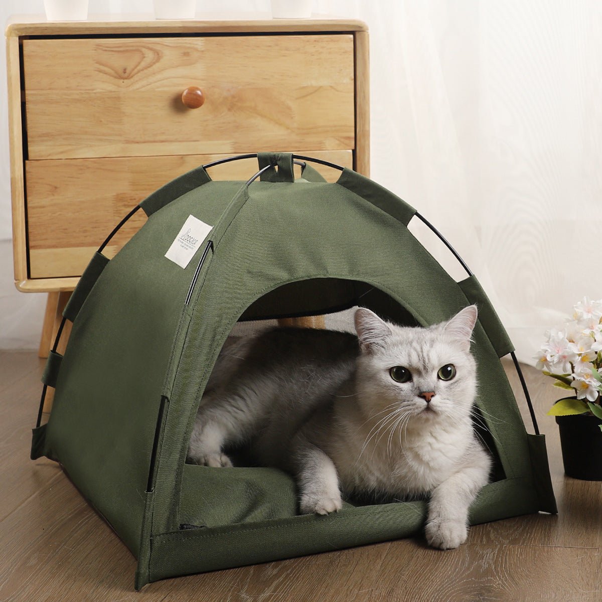 Cat cooling mat for pets inside a green tent, providing comfort for indoor use near a wooden drawer.